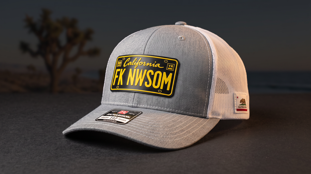 FK NWSOM California Leather Patch Trucker Hat — angled view of the black and yellow California-style leather patch on a grey and white Richardson 112 trucker hat